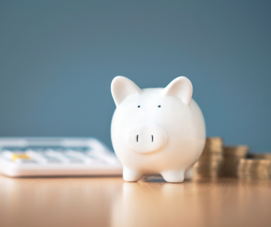 Piggy bank with a calculator and coins in the background