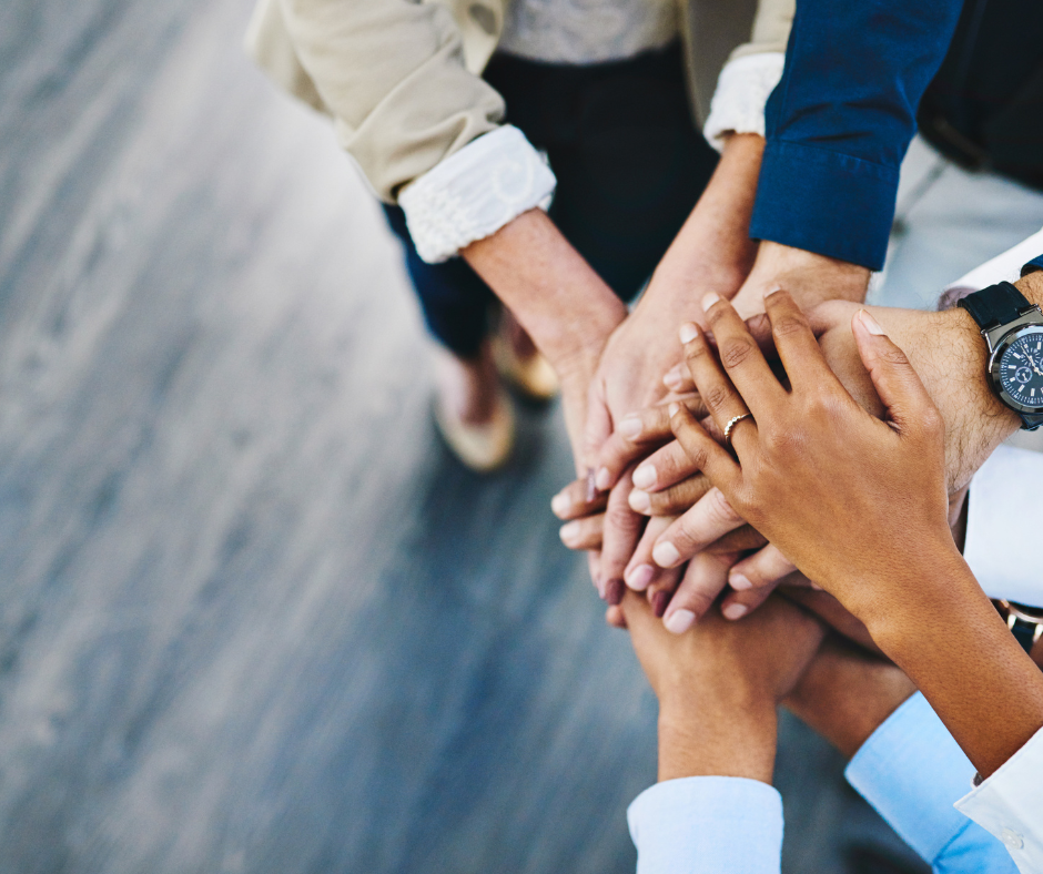 Shot of group of businesspeople joining their hands together in unity